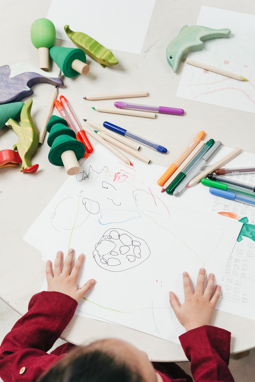 kid on white table painting