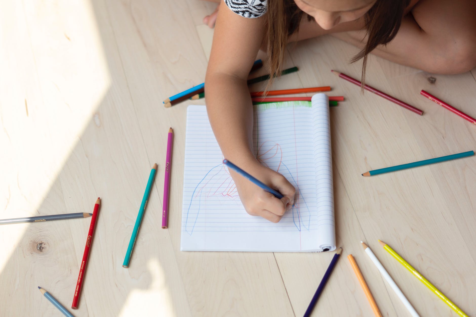 person drawing on a notebook