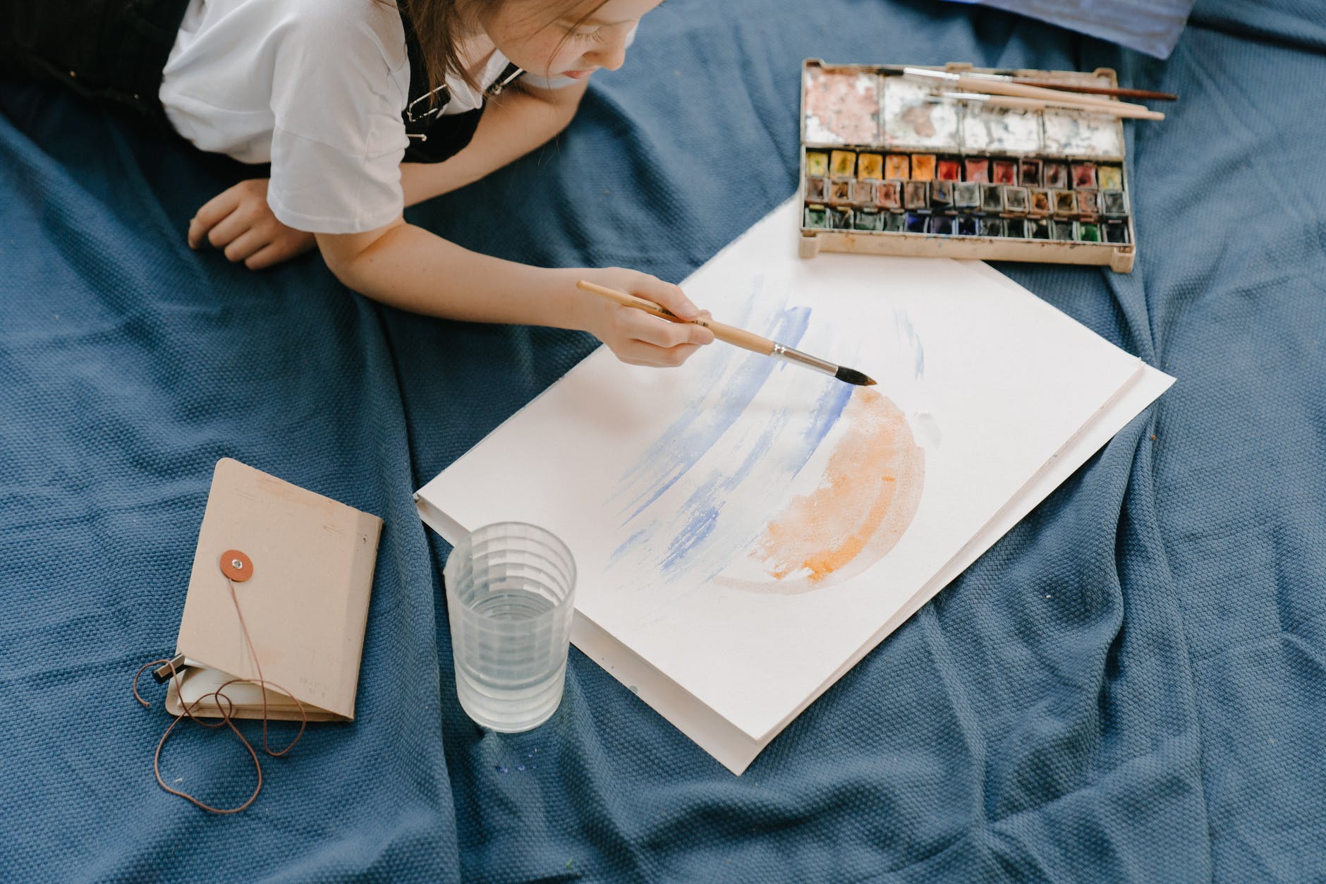 girl in white shirt holding paint brush